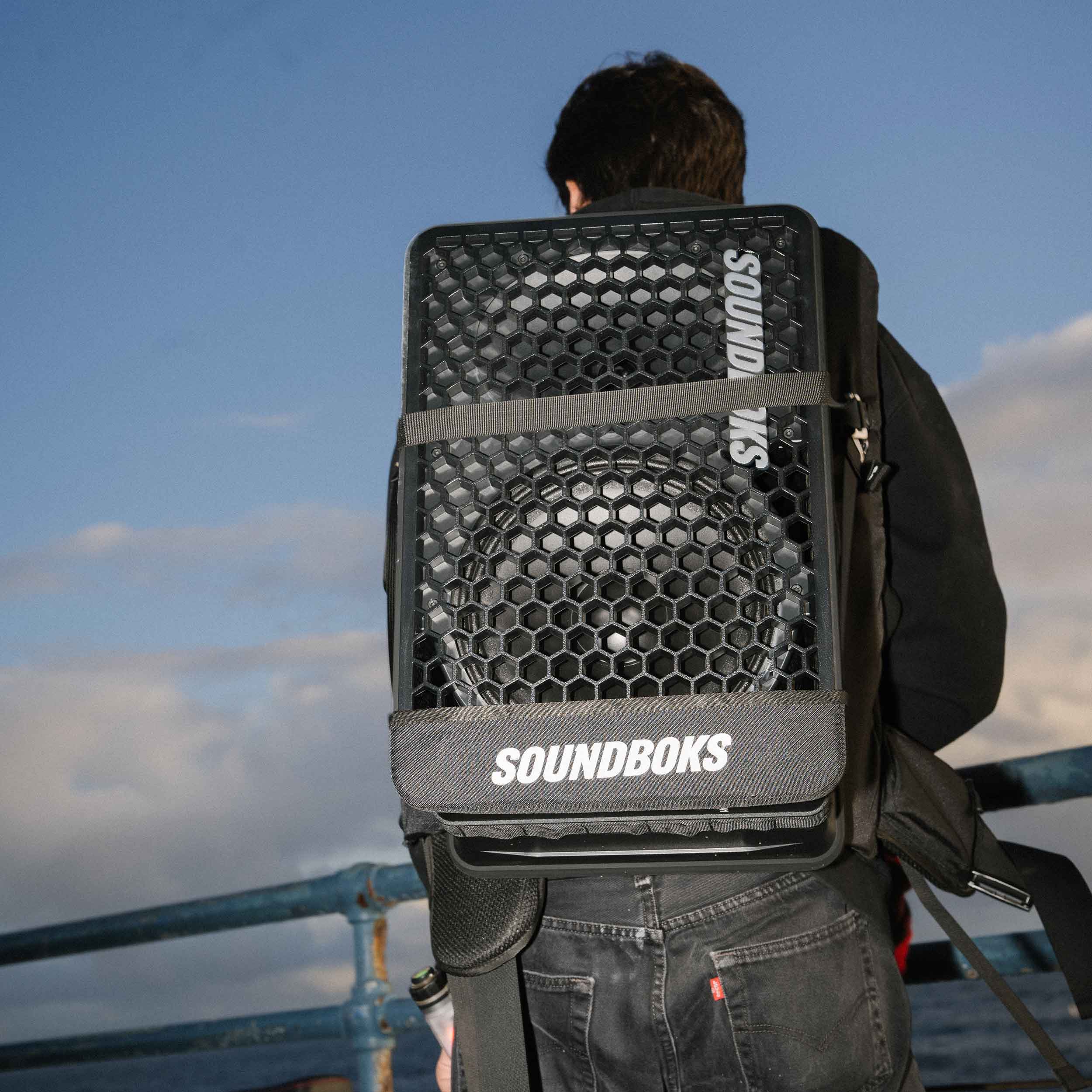 A person carrying the SOUNDBOKS Go in THE BACKPACK